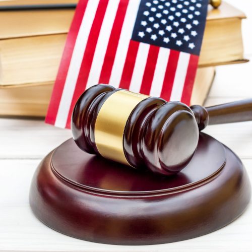 Judge's,Gavel,With,Books,And,American,Flag,On,White,Wooden